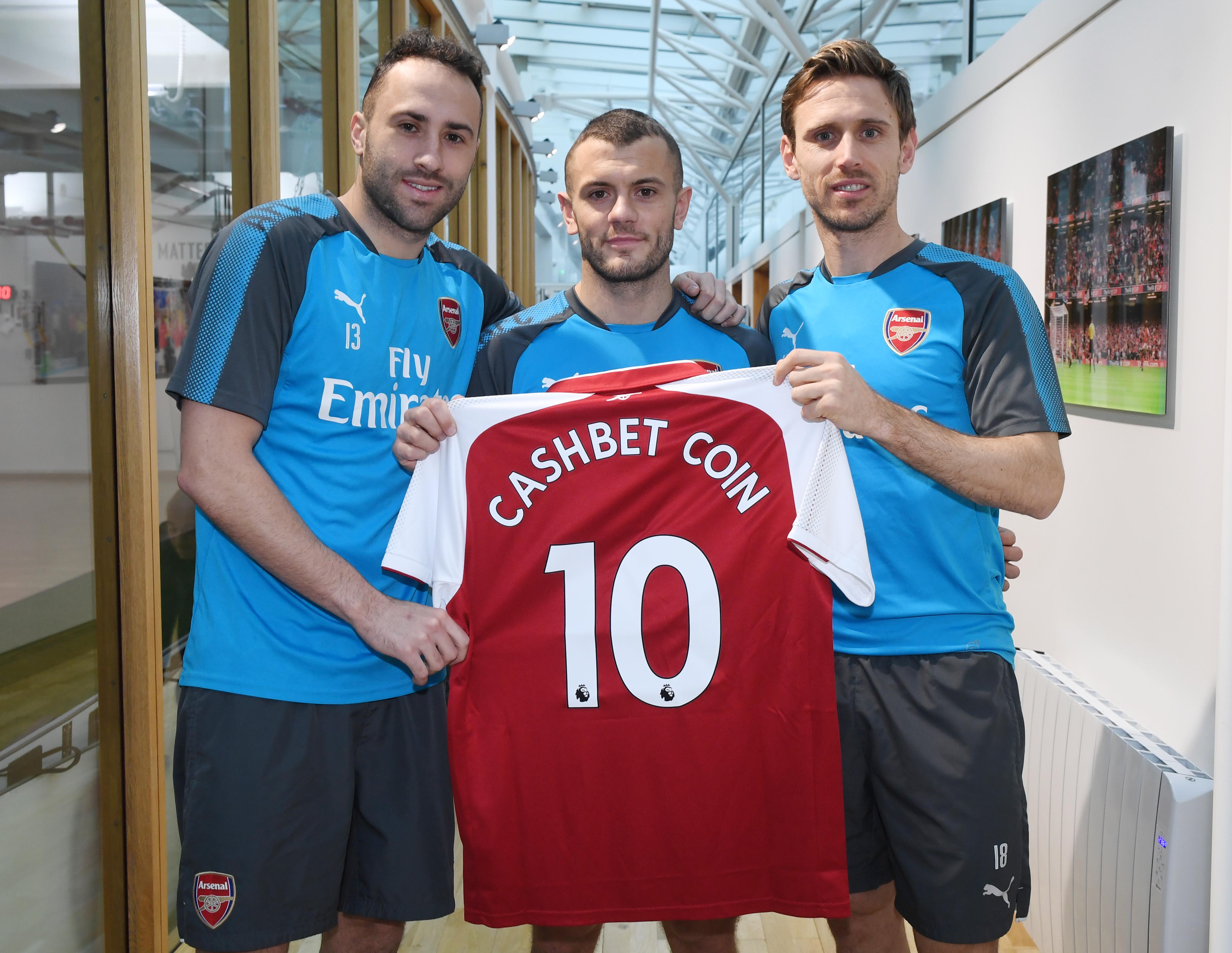  Ba trụ cột của Arsenal ở thời điểm hiện tại (từ trái qua) là thủ thành David Ospina, tiền vệ Jack Wilshere và trung vệ đội trưởng Per Mertesacker chụp ảnh quảng bá cho CashBet Coin.